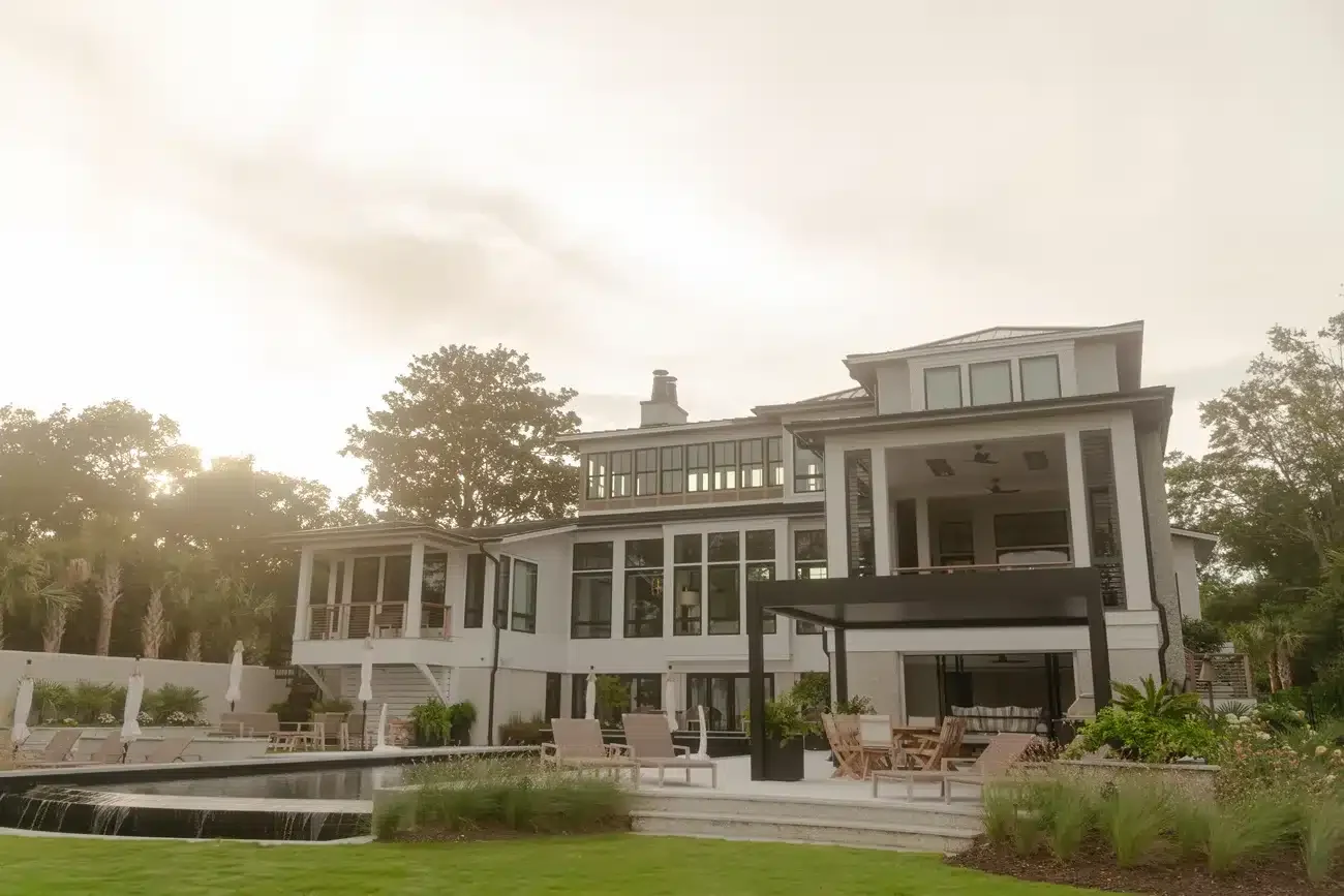Black Azenco R-BLADE™ motorized louvered pergola beside an outdoor kitchen and pool